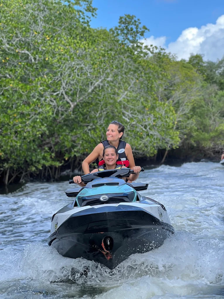 Guests riding jetski through mangrove river