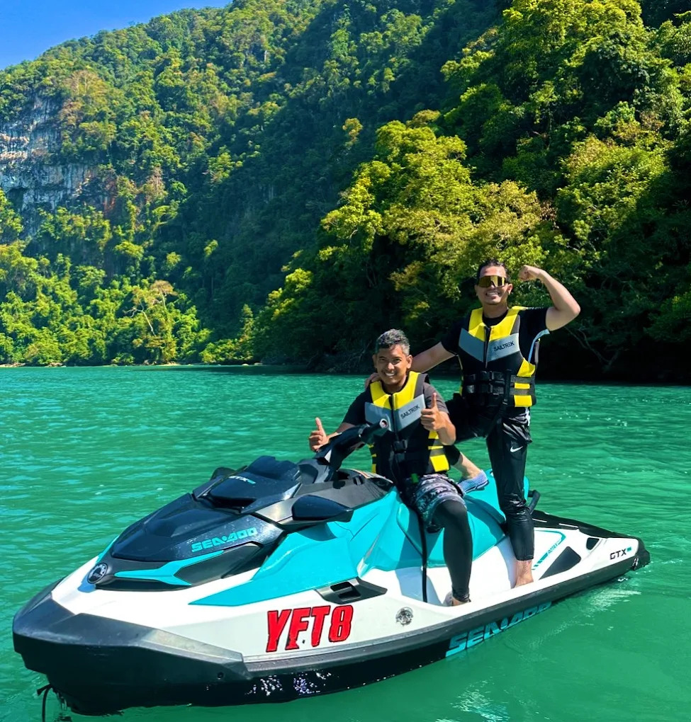 Jetski riders posing by Langkawi limestone cliffs
